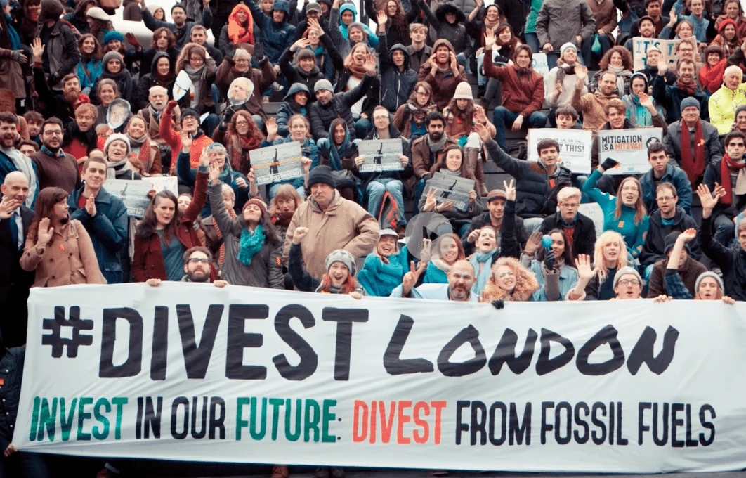 Fossil fuel divestment campaigners holding a Divest London banner.